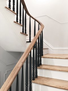 Stewart-Schafer finished the existing staircase and railings by hand. All of the spindles are painted black to give the traditional formwork a modern aesthetic.