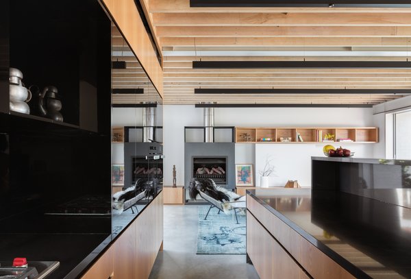 Continuously run wood slats visually connect the open living spaces while adding a warm, textural component. Black linear pendants are a contemporary way of introducing overhead light.