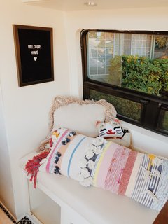 A lucky cat pillow from Urban Outfitters and a striped body pillow introduce color and personal style into the space.