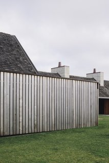 Timber-clad walls surround the home's indoor and outdoor living spaces.