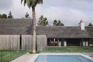 Large sliding glass doors open onto a backyard retreat complete with a fire pit and swimming pool. 