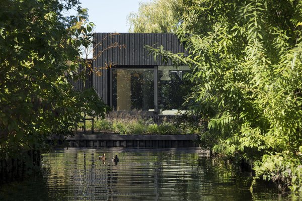 Dark timber cladding gives way to airy interiors at this compact holiday home near the Lakes of Vinkeveen in the Netherlands.