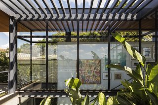 An interior courtyard is shaded by metal louvers above, filtering light into the living spaces.