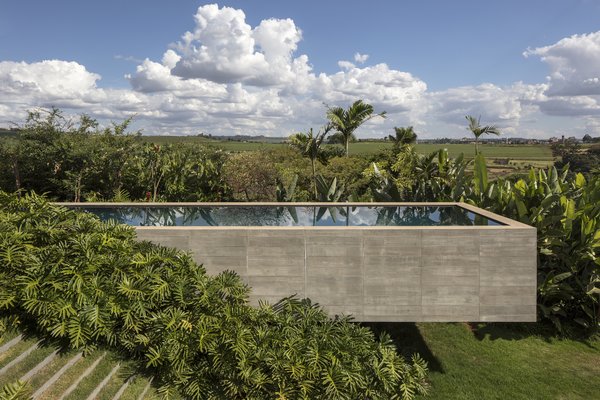 Sculptural in form, the concrete faced pool hovers gently above the hillside, while reflecting the sun and clouds as they pass overhead. 