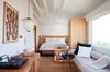 Modern home with Bedroom, Night Stands, Bed, Medium Hardwood Floor, Storage, Wall Lighting, Shelves, Bookcase, Dresser, Accent Lighting, and Pendant Lighting. A large picture window in premium room La Vue frames ocean views from sunrise to sunset. Photo 6 of Hotel Joaquin