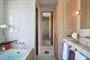 Modern home with Bath Room, Stone Counter, Soaking Tub, Ceramic Tile Floor, Wall Lighting, Ceramic Tile Wall, Alcove Tub, Accent Lighting, and Drop In Sink. Spa-like bathrooms are the ideal place for a little R&R. Photo 10 of Hotel Joaquin