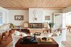 Modern home with Living Room, Coffee Tables, Stools, Media Cabinet, Chair, Sofa, Terra-cotta Tile Floor, Storage, Rug Floor, Standard Layout Fireplace, and Gas Burning Fireplace. Midcentury California beach culture and the classic look of the Mediterranean coast blend to create cozy, lush lounge spaces in this Laguna Beach retreat. Photo of Hotel Joaquin