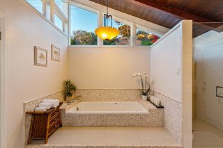 The spa-like master bath has been recently updated. Clerestory windows draw natural light into the space, while still providing privacy.