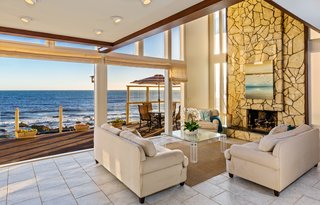 A dramatic, two-story stone fireplace anchors one end of the living room.