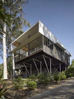 Panels of dark stained plywood and fiber cement conceal the interior living spaces.