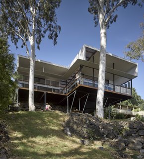 Slender columns support the cantilevered home above the rocky terrain, providing minimal disruption to the natural landscape.