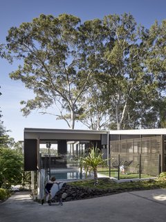 The swimming pool anchors the home to the rocky slope and enables its wood-framed platform to hover high above the terrain.