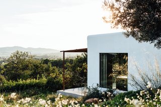 The home, located in a remote mountain field in the rugged north area of Ibiza, embraces its mountain views, Mediterranean climate, and Ibizan roots.