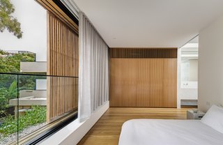 Layered elements, including a movable wood screen and interior curtains, provide plenty of options for comfort and privacy.