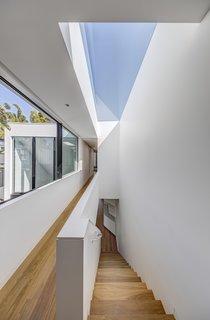 A large skylight mirrors the plan of the stairs, allowing light to fall into the corridors.