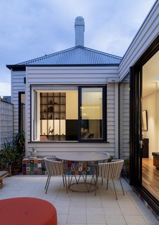 A central courtyard sits between the original cottage and the new addition.