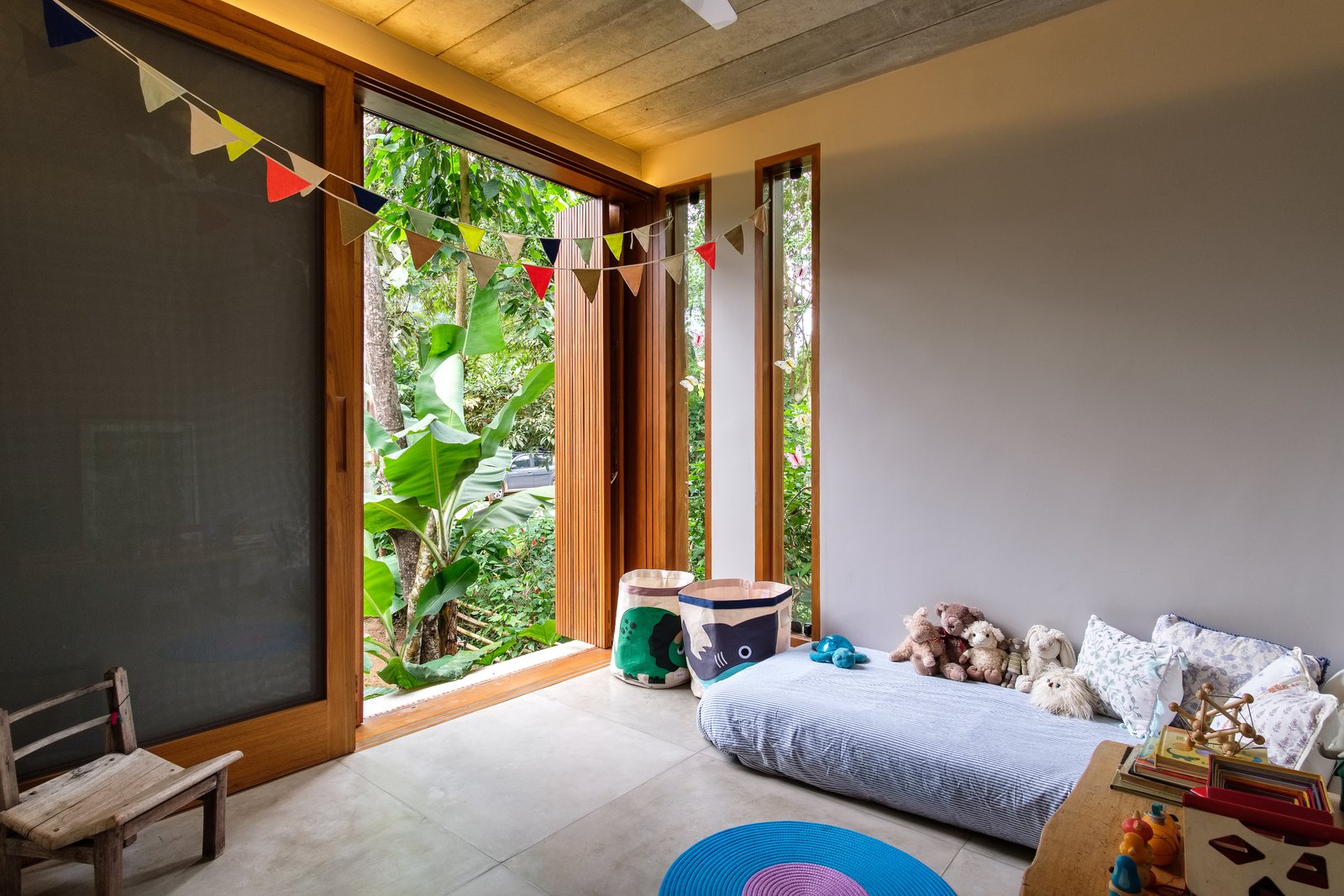 pittaarquitetura Dormitorio, cama y silla Las grandes aberturas con pantallas de madera móviles permiten ventilación, vistas y privacidad.