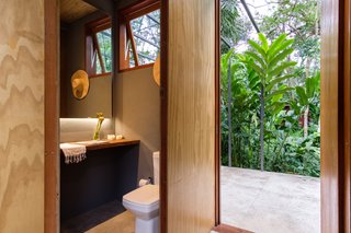 The minimal material palette extends into interior living spaces—including the bathrooms.