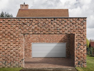 The open courtyard conceals and reveals the private parking garage for the home.