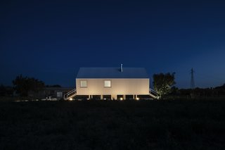 Illuminated from below, the home is a shining light against the dark sky.