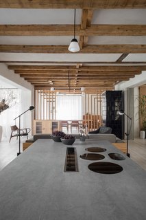 The new kitchen, with cooking surfaces in the central island, remains open to the main living spaces.