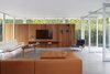 Modern home with Living Room, Chair, Ottomans, Coffee Tables, Sofa, Ceiling Lighting, Recessed Lighting, Floor Lighting, and Concrete Floor. The Serge Mouille floor lamp is paired with the Fabricius & Kastholm Grasshopper chair in the living room. The custom walnut cabinet is mounted on red cedar siding, which provides a dramatic backdrop for the Eames sofa and a Finn Juhl coffee table of solid walnut. Photo 3 of Santa Monica Residence