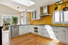 Modern home with Kitchen, Medium Hardwood Floor, Subway Tile Backsplashe, White Cabinet, Ceiling Lighting, Accent Lighting, Refrigerator, Recessed Lighting, Range Hood, Dishwasher, Cooktops, and Drop In Sink. The photo shows the shot from the dining room doorway through to the new porch Photo of The Yin Kitchen