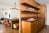 Modern home with Kitchen, Wood Counter, Wood Cabinet, Medium Hardwood Floor, Wood Backsplashe, Range, Recessed Lighting, Refrigerator, Range Hood, Microwave, Dishwasher, and Undermount Sink. Kitchen with view of Dining and Living Room beyond. Pendant light fixture by Chris McCullough Photo 8 of Boise Residence