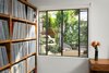 Modern home with Bookcase, Medium Hardwood Floor, Shelves, Storage, Casement Window Type, Metal, Bedroom, and Pendant Lighting. Bedroom with built-in wood shelves for records. Steel window with view to rear yard landscape and firepit Photo 9 of Boise Residence