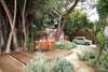 Modern home with Garden, Trees, Hardscapes, Shrubs, Walkways, and Pavers Patio, Porch, Deck. Raised deck at outdoor dining terrace with Mini Cooper and wood trash enclosure feature wall beyond Photo 20 of Boise Residence