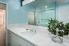 Modern home with Engineered Quartz Counter, Undermount Sink, Medium Hardwood Floor, Enclosed Shower, Recessed Lighting, Subway Tile Wall, Two Piece Toilet, Windows, Awning Window Type, and Metal. Guest bathroom with clerestory above and Kitchen / Dining Room beyond Photo 10 of Allaseba Residence