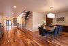 Modern home with Chair, Pendant Lighting, Table, Bar, Recessed Lighting, Medium Hardwood Floor, Metal, Exterior, Swing Door Type, Staircase, Wood Tread, and Glass Railing. Dining Room and staircase with Entry beyond Photo 9 of Bowling Green Residence