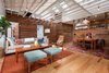 Modern home with Chair, Sofa, Coffee Tables, Bench, Light Hardwood Floor, Ottomans, Pendant Lighting, Doors, Swing Door Type, Wood, and Interior. Living Room looking East towards bedrooms and bathroom hidden behind reclaimed wood siding clad walls Photo 2 of Ashland Residence
