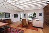 Modern home with Chair, Sofa, Console Tables, Pendant Lighting, Coffee Tables, Bench, Ottomans, Light Hardwood Floor, Sliding Window Type, Metal, Doors, Interior, Wood, and Swing Door Type. Living Room looking North towards Entry, Study and front yard with open ceiling framing and pendant lighting Photo 3 of Ashland Residence