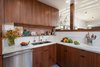 Modern home with Kitchen, Marble Counter, Brick Backsplashe, Marble Backsplashe, Light Hardwood Floor, Wood Cabinet, Recessed Lighting, Refrigerator, Range, Range Hood, Dishwasher, and Undermount Sink. Kitchen with American Black Walnut cabinets and Calacatta marble countertops open to Living Room on right. Original red brick exposed above backsplash Photo 5 of Ashland Residence