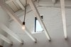 Modern home with Living Room and Pendant Lighting. Detail of open ceiling framing, pendant light and window (former attic vent) within existing painted brick wall Photo 6 of Ashland Residence