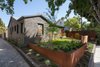 Modern home with Outdoor, Front Yard, Garden, Side Yard, Trees, Grass, Hardscapes, Gardens, Raised Planters, Walkways, Wood Fences, Wall, Pavers Patio, Porch, Deck, Horizontal Fences, Wall, and Metal Fences, Wall. Front yard entry at driveway apron with corten landscape walls and gate beyond Photo 9 of Ashland Residence