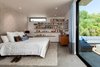 Modern home with Bed, Bookcase, Dresser, Storage, Night Stands, Shelves, Recessed Lighting, Concrete Floor, Awning Window Type, Metal, Doors, Sliding Door Type, and Exterior. Bedroom at rear yard opens to patio Photo 11 of Ashland Residence