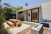 Modern home with Trees, Back Yard, Garden, Hardscapes, Gardens, Walkways, Small Patio, Porch, Deck, Decomposed Granite Patio, Porch, Deck, Concrete Patio, Porch, Deck, Vertical Fences, Wall, Wood Fences, Wall, Landscape Lighting, Exterior, Metal, Sliding Door Type, Windows, and Awning Window Type. Outdoor dining room and firepit with bedroom beyond Photo 12 of Ashland Residence