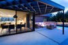 Modern home with Outdoor, Back Yard, Side Yard, Trees, Shrubs, Hardscapes, Walkways, Small Pools, Tubs, Shower, Swimming Pools, Tubs, Shower, Concrete Pools, Tubs, Shower, Small Patio, Porch, Deck, Wood Patio, Porch, Deck, Pavers Patio, Porch, Deck, Decomposed Granite Patio, Porch, Deck, Landscape Lighting, Concrete Patio, Porch, Deck, Horizontal Fences, Wall, and Wood Fences, Wall. Patio under pergola with Dining Room and Kitchen at interior beyond. Swimming pool beyond at far rear of property. Photo 18 of Las Casas Residence