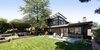 Modern home with Outdoor, Back Yard, Garden, Field, Woodland, Trees, Shrubs, Grass, Hardscapes, Gardens, Wood Patio, Porch, Deck, Flowers, Walkways, Hot Tub Pools, Tubs, Shower, Large Patio, Porch, Deck, Decking Patio, Porch, Deck, Planters Patio, Porch, Deck, Horizontal Fences, Wall, Retaining Fences, Wall, and Concrete Fences, Wall. Backyard panoramic with raised deck, pergola and hot tub beyond Photo 2 of Ridgemont Residence