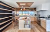 Modern home with Kitchen, Light Hardwood Floor, Range Hood, Range, Refrigerator, Undermount Sink, Pendant Lighting, Wood Cabinet, Marble Counter, Ceramic Tile Backsplashe, Recessed Lighting, and Dishwasher. Additional seating at the island for informal rap sessions with mom and dad. Kitchen looking West towards the side yard with layers of filtered light from the South facing windows at the top of the adjacent stair as well as the light well over the island with emerging cluster of custom ceramic pendants from Heather Levine. The kitchen is balanced with planes of white oak, white Cle tile, stainless steel appliances and Carrara marble. Photo 9 of Ashland Residence