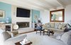 Modern home with Living Room, Chair, Sofa, End Tables, Bookcase, Gas Burning Fireplace, Table Lighting, and Medium Hardwood Floor. Living Room Photo of Stunning Beach House