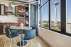 Modern home with Dining Room, Ceiling Lighting, Shelves, Chair, Table, Medium Hardwood Floor, and Light Hardwood Floor. The look of the room was driven by Seattle and the northwest, with a particular focus on northwest music. Plaid draperies invoke the feeling of the early ‘90’s Seattle grunge scene, while providing privacy and light control. Photo 18 of Emerald City Studio