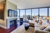 Modern home with Living Room, Sofa, Sectional, Coffee Tables, End Tables, Ottomans, Chair, Ceiling Lighting, Floor Lighting, Carpet Floor, Medium Hardwood Floor, Standard Layout Fireplace, and Gas Burning Fireplace. The living area showcases an amazing view of Puget Sound and downtown Seattle. Sectional from Patricia Edwards upholstered in AST fabric; cocktail table from Wendell Castle and the couples' original Eames Lounger. Photo 17 of Downsize Upstyle