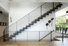 Laser cut steel stair stringer with 2" solid white oak treads and open risers lead to the master suite level on the 3rd floor. Photo 9 of Riverwood modern home
