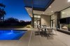 Modern home with Outdoor, Back Yard, Pavers Patio, Porch, Deck, Swimming Pools, Tubs, Shower, and Vertical Fences, Wall. The angle of roof allows the interior spaces to open up to the views beyond without cutting off the tops of the mountains in the distance while also forcing the roof water back towards two rain water collection main points. The simplicity of the roof design helps create a straight forward rain collection system. Photo 14 of Arroyo House