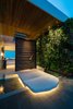 Modern home with House Building Type, Wood Siding Material, Concrete Siding Material, Metal Siding Material, Stone Siding Material, Green Roof Material, Front Yard, Walkways, Grass, Gardens, Hardscapes, Large Patio, Porch, Deck, Stone Patio, Porch, Deck, Wood Patio, Porch, Deck, Concrete Patio, Porch, Deck, Tile Patio, Porch, Deck, Metal Patio, Porch, Deck, Landscape Lighting, Exterior, and Swing Door Type. Main entrance to the house consists of a solid limestone bridge suspended over a reflecting pool and a 6'x 9’ custom pivot door floating inside a frameless glass facade.
Photo 9 of Trousdale Place Residence