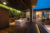 Modern home with Back Yard, Trees, Shrubs, Large Patio, Porch, Deck, Decking Patio, Porch, Deck, Landscape Lighting, Living Space Room Type, Living Room Room Type, Family Room Room Type, House Building Type, Metal Roof Material, Wood Siding Material, Metal Siding Material, Exterior, and Wood. The structure of the pool house consists of a series of cantilevered steel frames allowing the pool house to be free from walls, allowing the facade and views to open up to the surrounding views. Photo 19 of Trousdale Place Residence