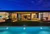 Modern home with House Building Type, Metal Roof Material, Wood Siding Material, Back Yard, Trees, Shrubs, Grass, Hardscapes, Gardens, Large Pools, Tubs, Shower, Swimming Pools, Tubs, Shower, Large Patio, Porch, Deck, Decking Patio, Porch, Deck, and Landscape Lighting. Floor to ceiling glazing provides expansive views for both living and dining spaces.
Photo 17 of Trousdale Place Residence